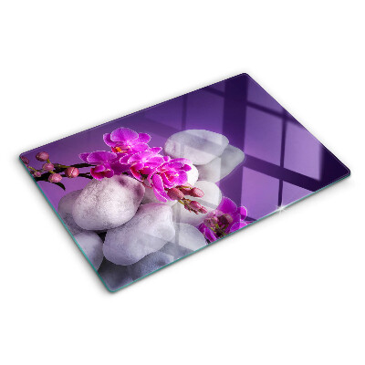 Skleněná deska do kuchyně Květy orchidejí na pozadí kamenů