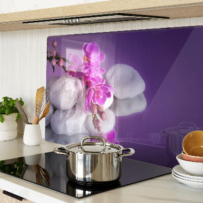 Skleněná deska do kuchyně Květy orchidejí na pozadí kamenů