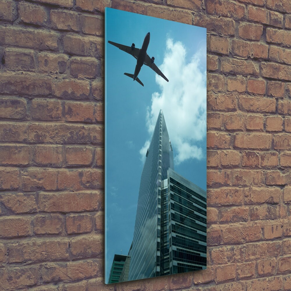 Vertikální Fotoobraz na skle Letadlo nad městem