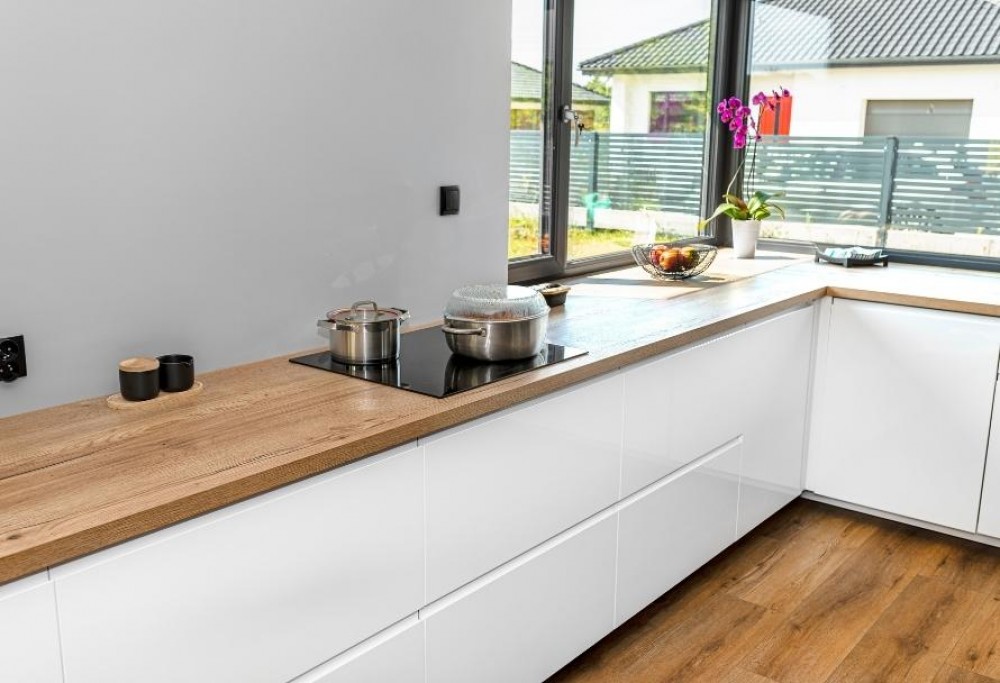 bílý kuchyňský nábytek s dřevěnou pracovní deskou